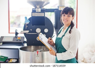 Woman Working On Coffee Factory Standing Near The Roasting Machine