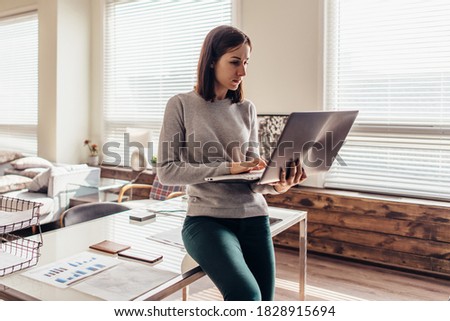 Woman working on laptop computer sitting on table