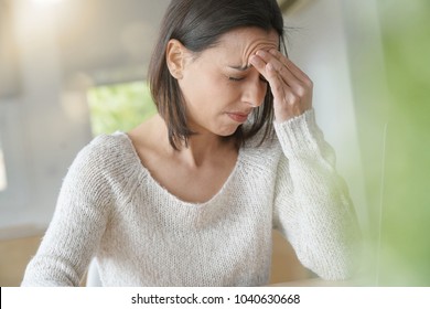 頭痛がするノートパソコンを使用している女性