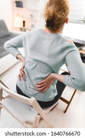 Woman working on a laptop and having back, hip, spine pain. - Shutterstock ID 1640766670