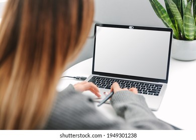 Woman Working On Laptop At Home With Blank White Screen Ready For Content