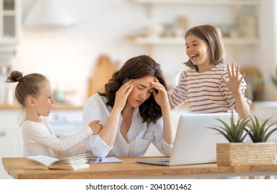 Woman Working On A Laptop. Noisy Children And Remote Work From Home. 