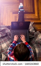 Woman Working On A Laptop While Sitting On The Floor, Top View. The Concept Of Remote Work. Freelance. Work At Home. Hard Worker.