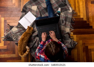 Woman Working On A Laptop While Sitting On The Floor, Top View. The Concept Of Remote Work. Freelance. Work At Home. Hard Worker.