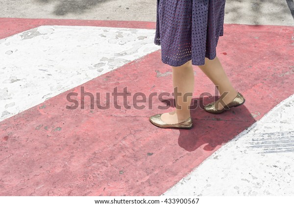 the woman working on no\
parking red cross zone.criss-cross red and white lines painted on\
the road