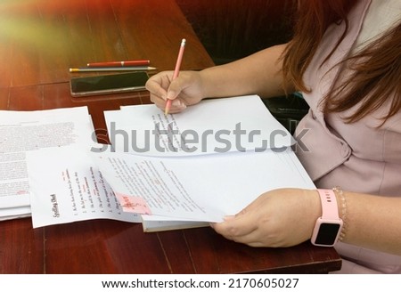 woman working on paperwork on table for proofreading service 