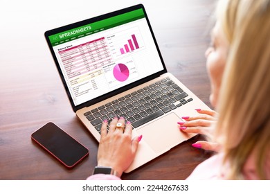 Woman working on spreadsheets on laptop