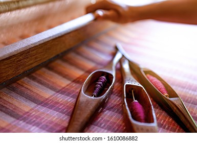 Woman working on weaving machine for weave handmade fabric. Textile weaving. Weaving using traditional hand weaving loom on cotton strands. Textile or cloth production in Thailand. Asian culture. - Shutterstock ID 1610086882