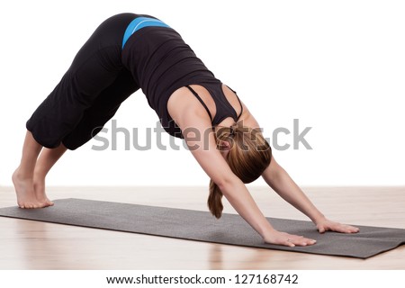 Woman working out at a gym arching her body in the air above a mat balancing on her arms and toes exerting muscular control in a health and fitness concept
