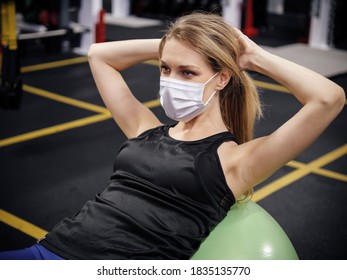 Woman Working Out At Gym With Protective Face Mask During Pandemic