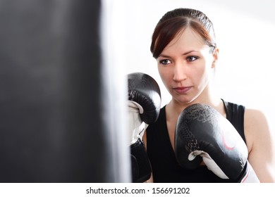 Woman Working Out On Punch Bag In Gym