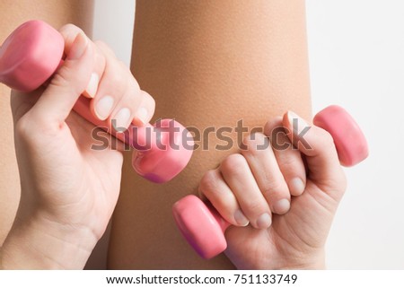Woman working out with pink dumbbells. Sporty activities. Cares about body. Sport concept.
