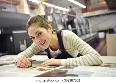 Woman working in print shop, checking document