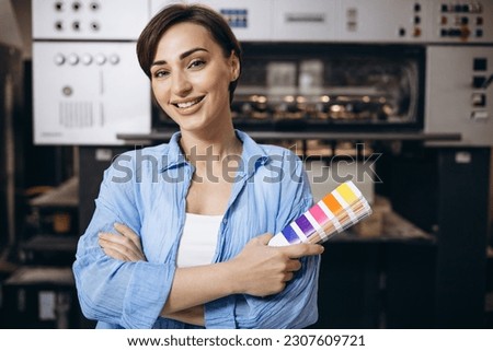 Woman working in printing house holding swatch palette