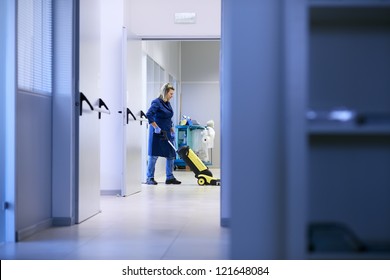 Woman working, professional maid cleaning and washing floor with machinery in industrial building