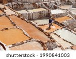 Woman working in salt terraces of Maras near Sacred Valey in Cusco, Perú.