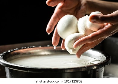 A woman working in a small family creamery is processing the final steps of making a cheese. Italian hard cheese silano or caciocavallo, mozzarella.