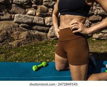 Woman in Workout Gear Kneeling on Mat - Powered by Shutterstock