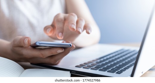 The woman works at home and uses a smart phone and a notebook laptop computer. Silhouette of a busy woman. She holds and using phone. - Powered by Shutterstock