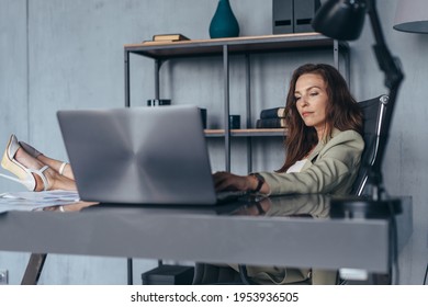 Woman Works Sitting With Her Legs Up On Her Desk