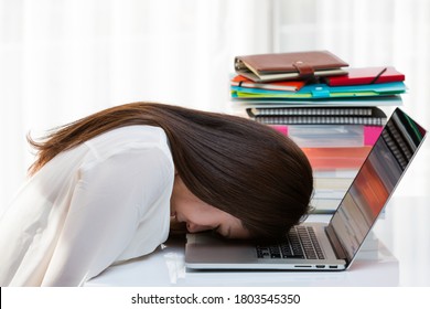 A woman is worried about having her head on a laptop. - Shutterstock ID 1803545350