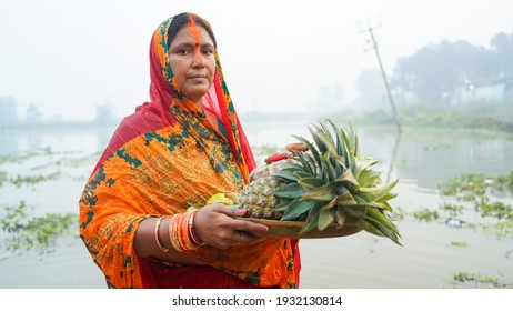 Woman Worshipping Holding Fruits In Hand During Chhath Pooja