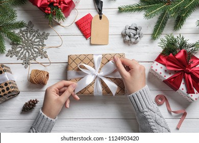 Woman Wrapping Christmas Gift At Wooden Table, Top View