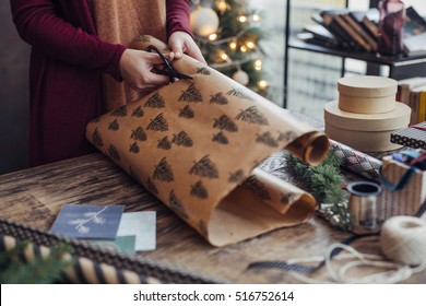 Woman Wrapping And Decorating Christmas Present