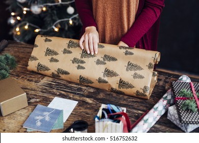 Woman Wrapping And Decorating Christmas Present