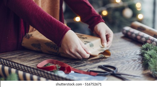 Woman Wrapping And Decorating Christmas Present