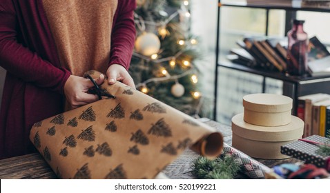 Woman Wrapping And Decorating Christmas Present