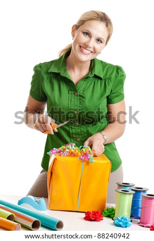 Woman wrapping a gift isolated on a white background