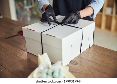 Woman Wrapping A Gift Using A Black Grosgrain Ribbon