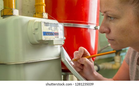 Woman Writes Indication Gas Meter In Notebook.