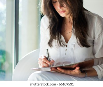 Woman writes on a paper