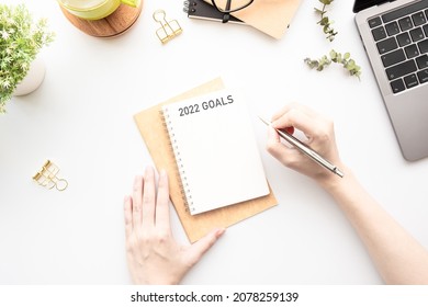 Woman Is Writing 2022 Goals For New Year Resolutions Plan.