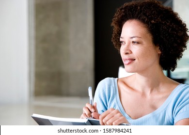 Woman Writing A Diary Or Journal At Home