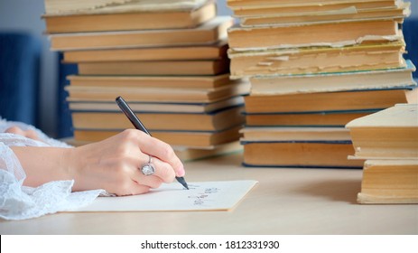 Woman Writing Essay Or Love Letters On A Piece Of White Paper In Library. Closeup Of Female Hands With Ring,  Writing Notes. Handwritten Text