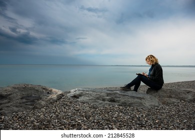 Woman Writing Her Thoughts Or Poetry By The Sea