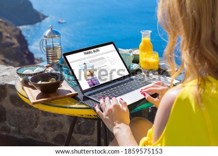 Woman writing her travel blog on laptop