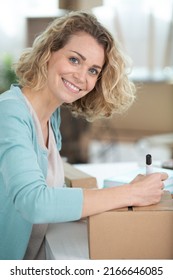 Woman Writing Label On A Parcel