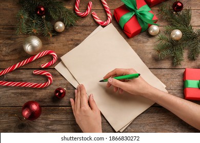 Woman writing letter to Santa Claus at wooden table, top view. Christmas celebration - Powered by Shutterstock