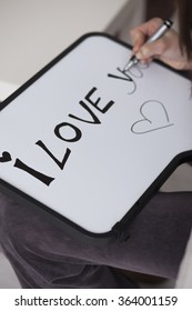 Woman writing I love you message white board  Love message writing selective focus