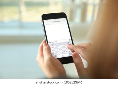 Woman writing message with text I Love You on smartphone against blurred background, closeup - Shutterstock ID 1952523646