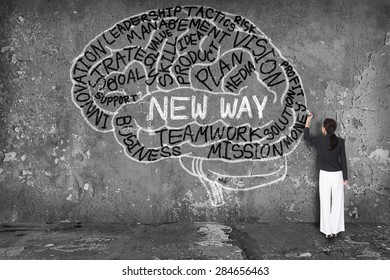 woman writing new way with brain on wall