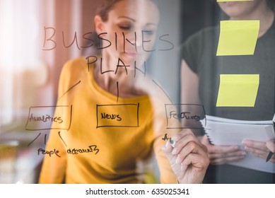 Woman Writing Notes On The Glass Board At The Office