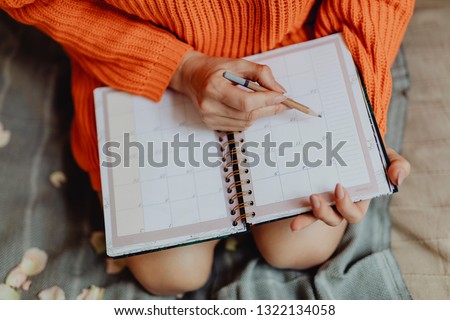 Woman writing on her daily planner