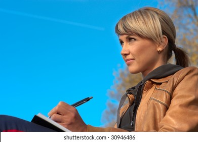 Woman Writing In A Park, Sky On The Background.