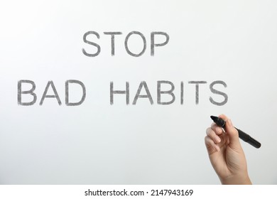 Woman Writing Phrase Stop Bad Habits On Glass Against White Background, Closeup