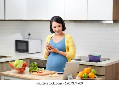 Woman Writing Shopping List On Kitchen